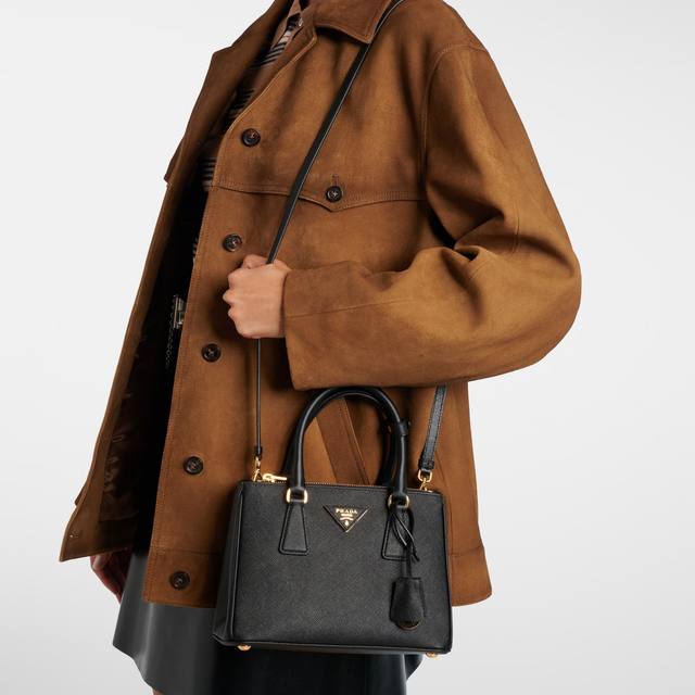 Prada Galleria Small in black Saffiano leather, worn with a brown suede jacket