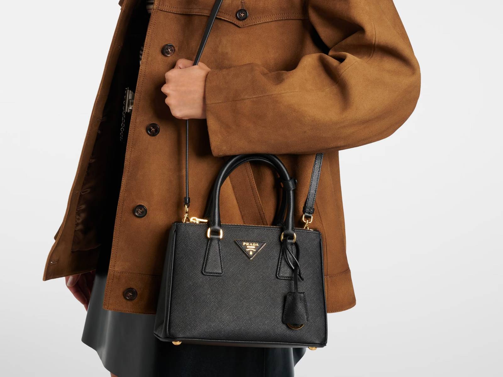 Prada Galleria Small in black Saffiano leather, worn with a brown suede jacket